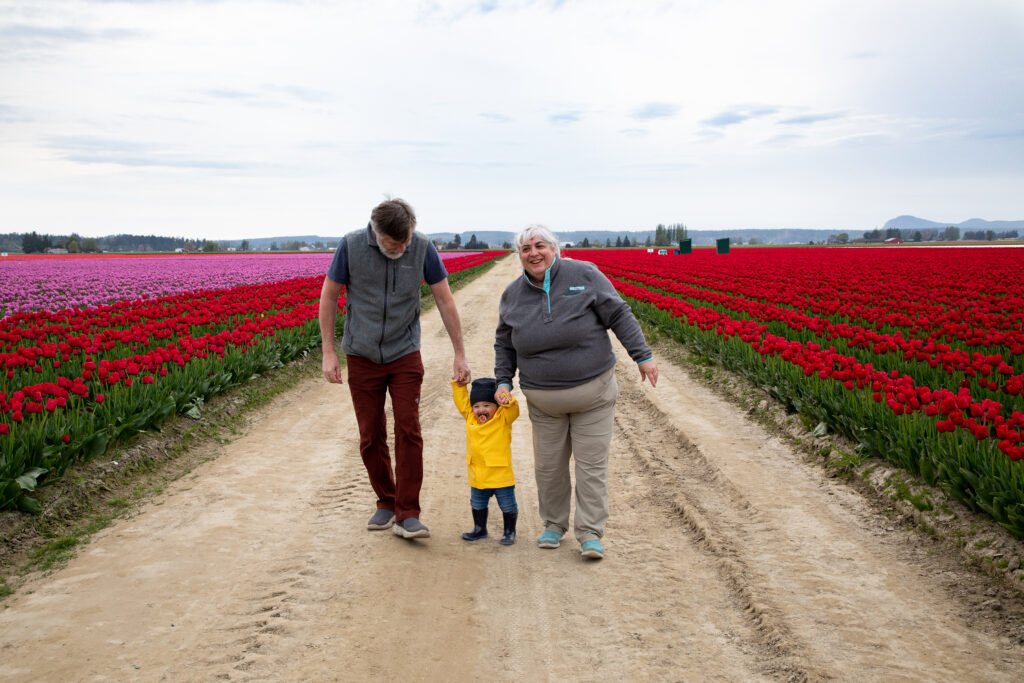 Grandpa Jim and Grandma Corinne walk with AJ through the tulip fields of Washington.