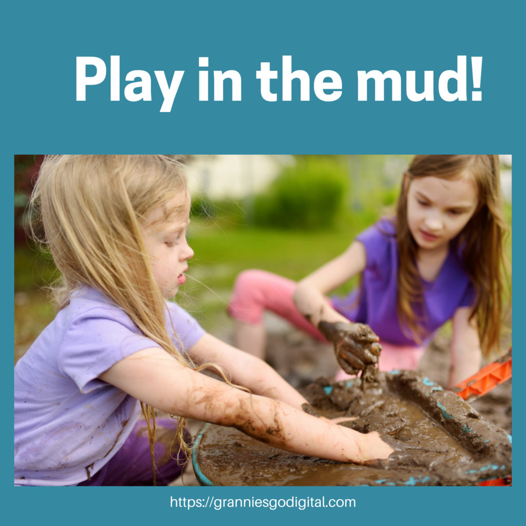 2 girls play in the mud.